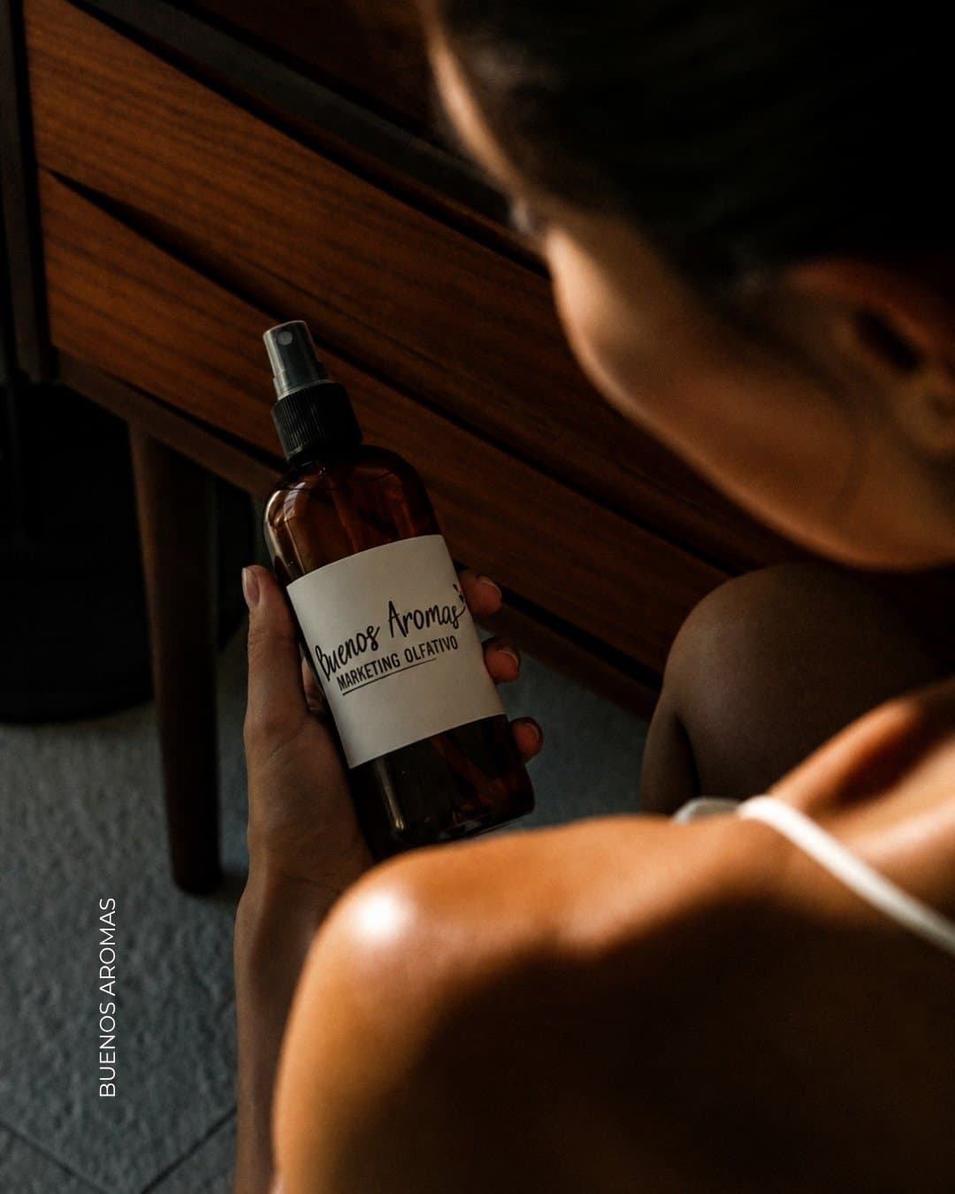 Home spray de vidrio ámbar sobre la mesita de luz de un dormitorio, de noche